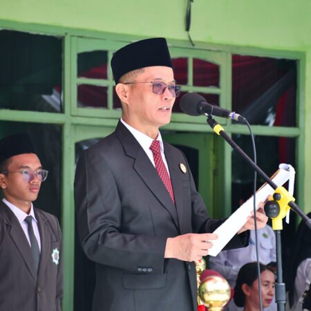 Syafitri Irwan membacakan sambutan Menteri Agama RI Nasaruddin Umar saat Upacara HAB ke-80 Kemenag di MAN 3 Palembang, menekankan pentingnya kerukunan umat dan kedaulatan AI.