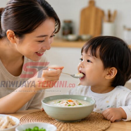 5 Manfaat Memberikan Bubur untuk Anak Setiap Pagi, Nomor 3 Bantu Daya Tahan Tubuh! Seorang ibu memberikan semangkuk bubur hangat kepada anak saat sarapan pagi dengan suasana dapur yang cerah. (Foto: dok/sriwijayaterkini.co)